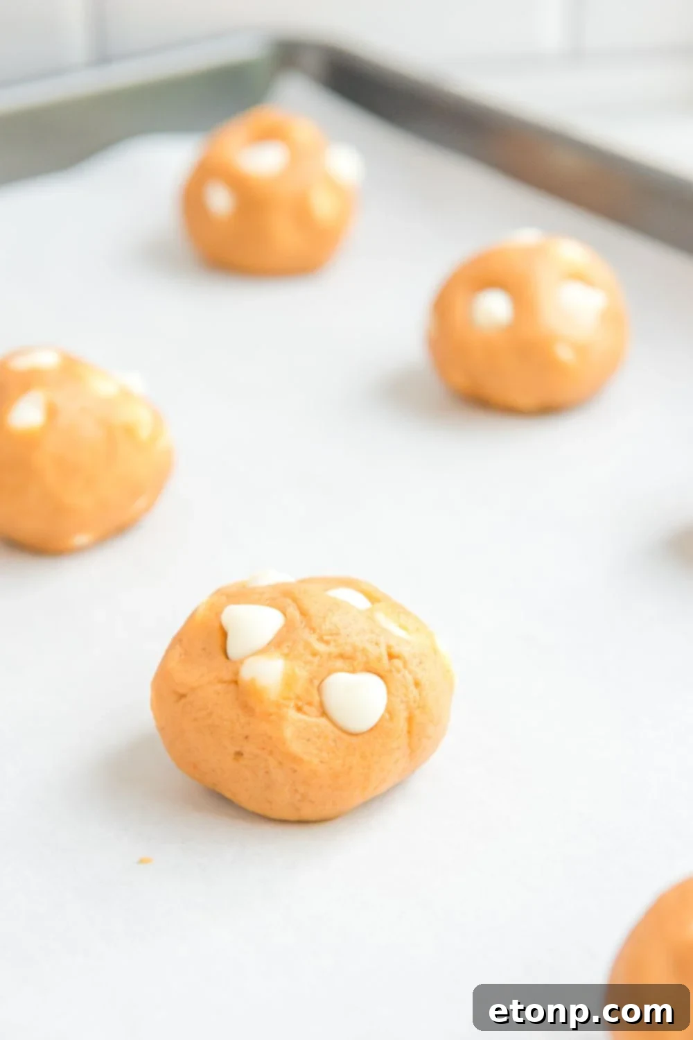 pumpkin cookie dough balls on cookie sheet