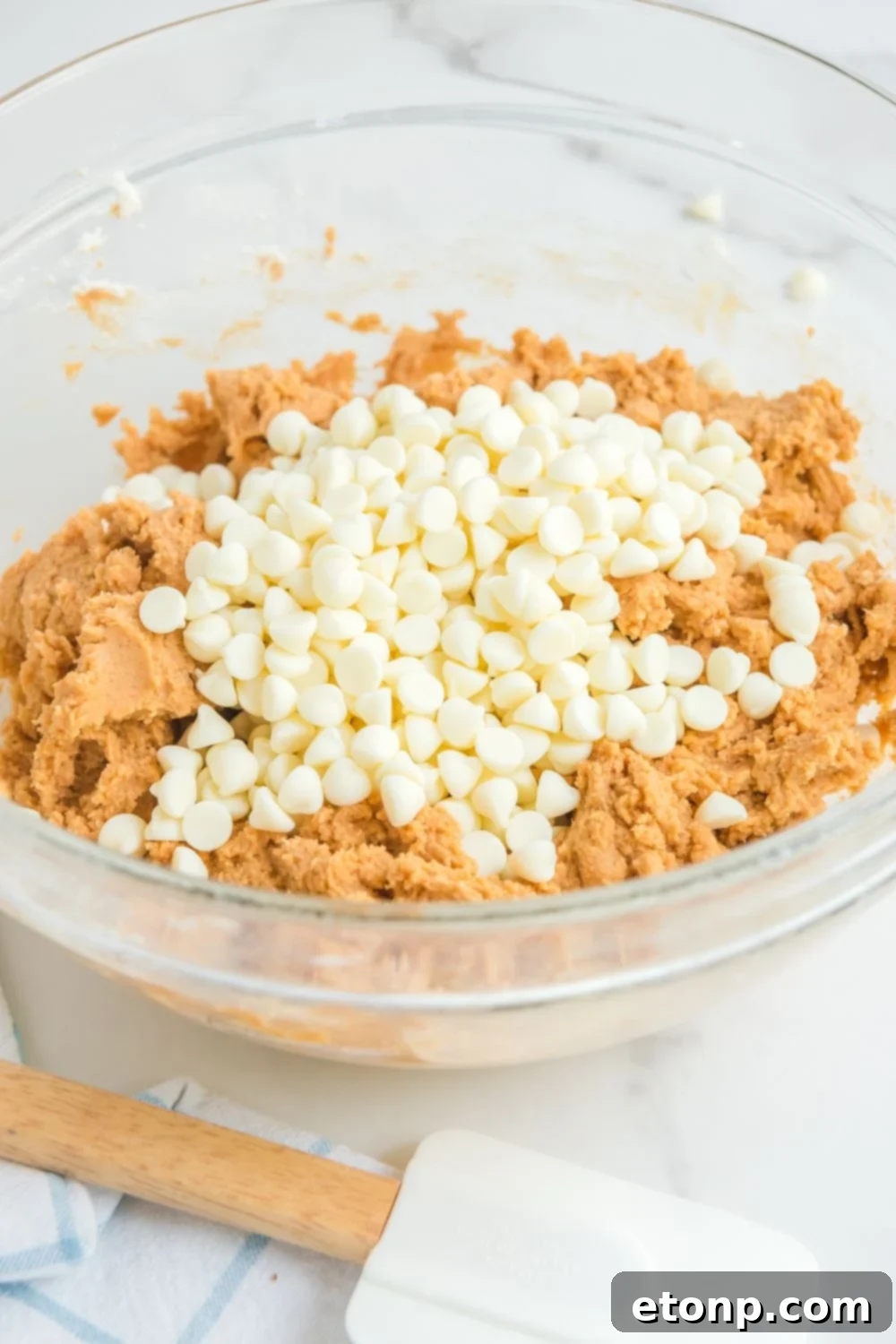 white chocolate chips on top of the pumpkin cookie dough 