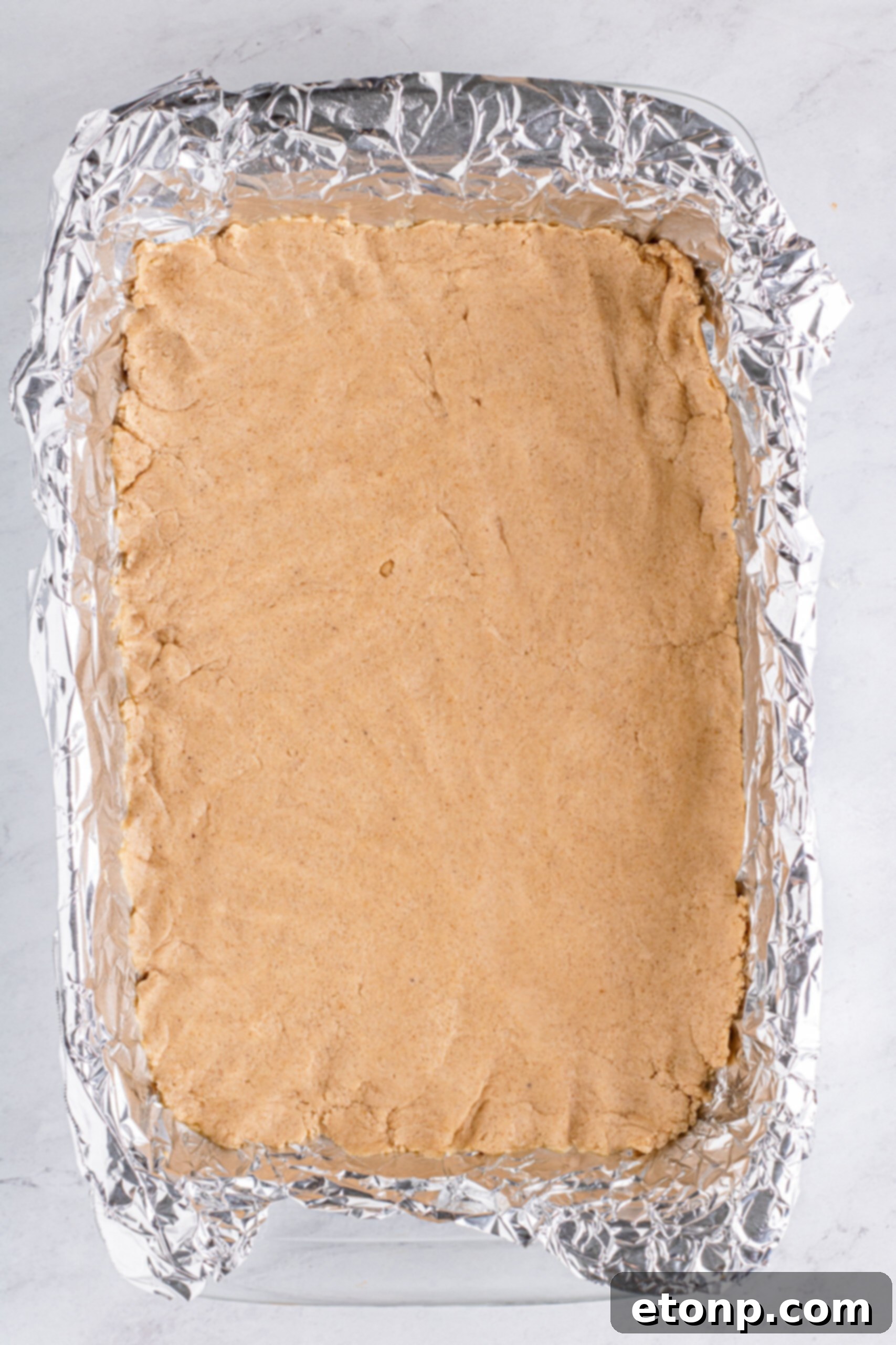 Sweet Autumn Pumpkin Crumble Bars 11 Crust for pumpkin bars in baking pan with foil