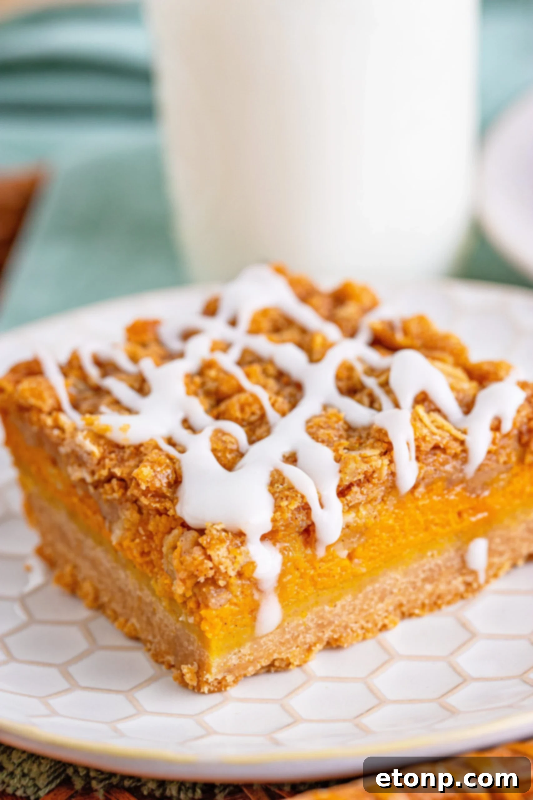 Sweet Autumn Pumpkin Crumble Bars 17 Side view of pumpkin streusel bar on plate with milk