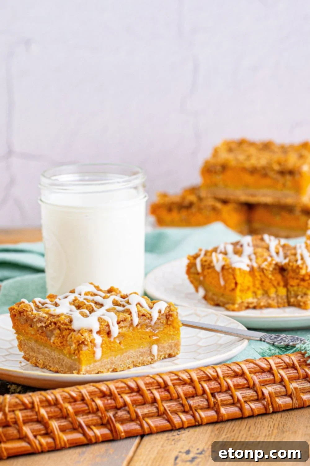 Sweet Autumn Pumpkin Crumble Bars 5 Streusel pumpkin bars on a serving tray with a glass of milk behind it
