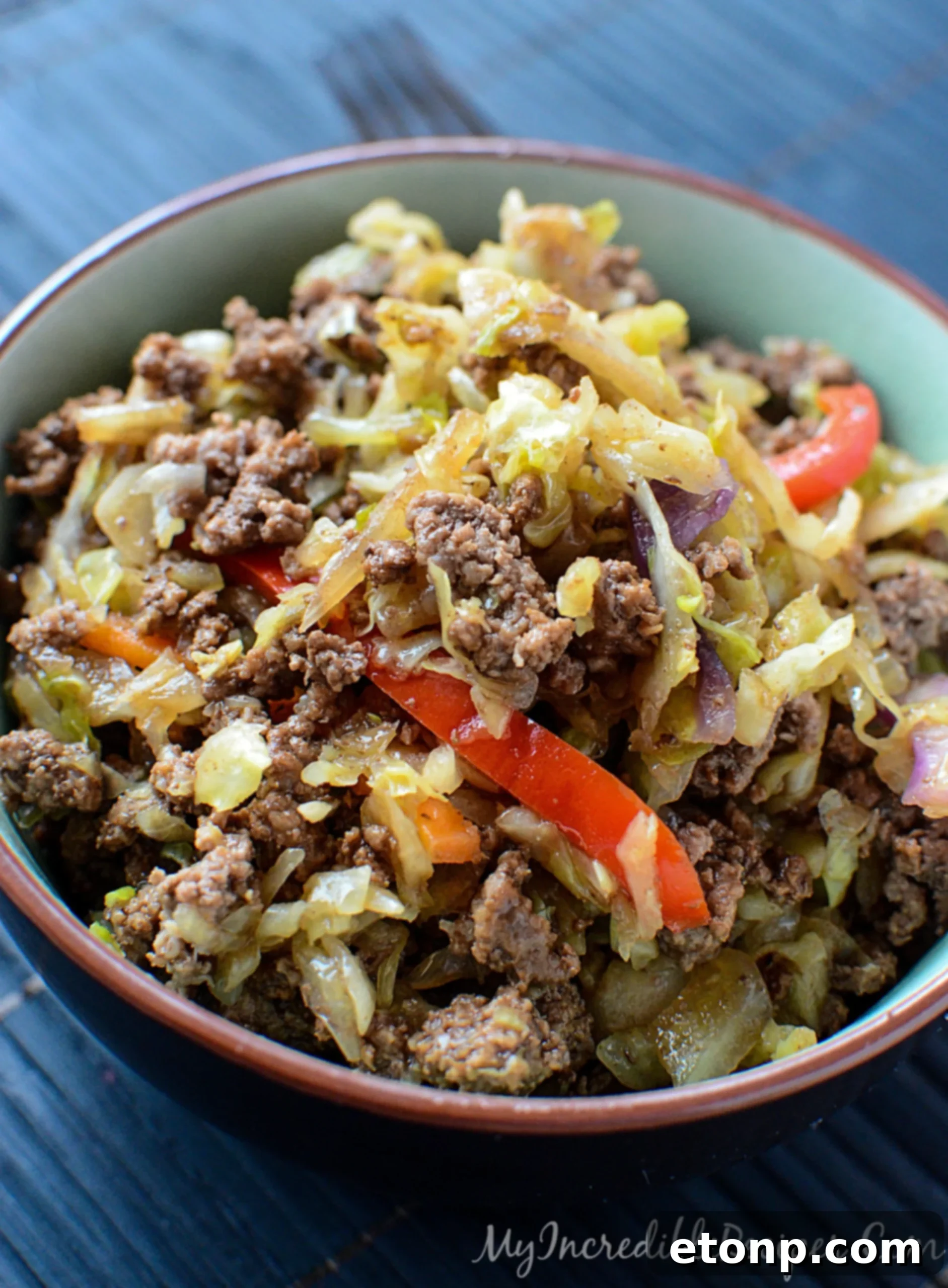 A large portion of Asian beef and cabbage stir fry in a serving dish