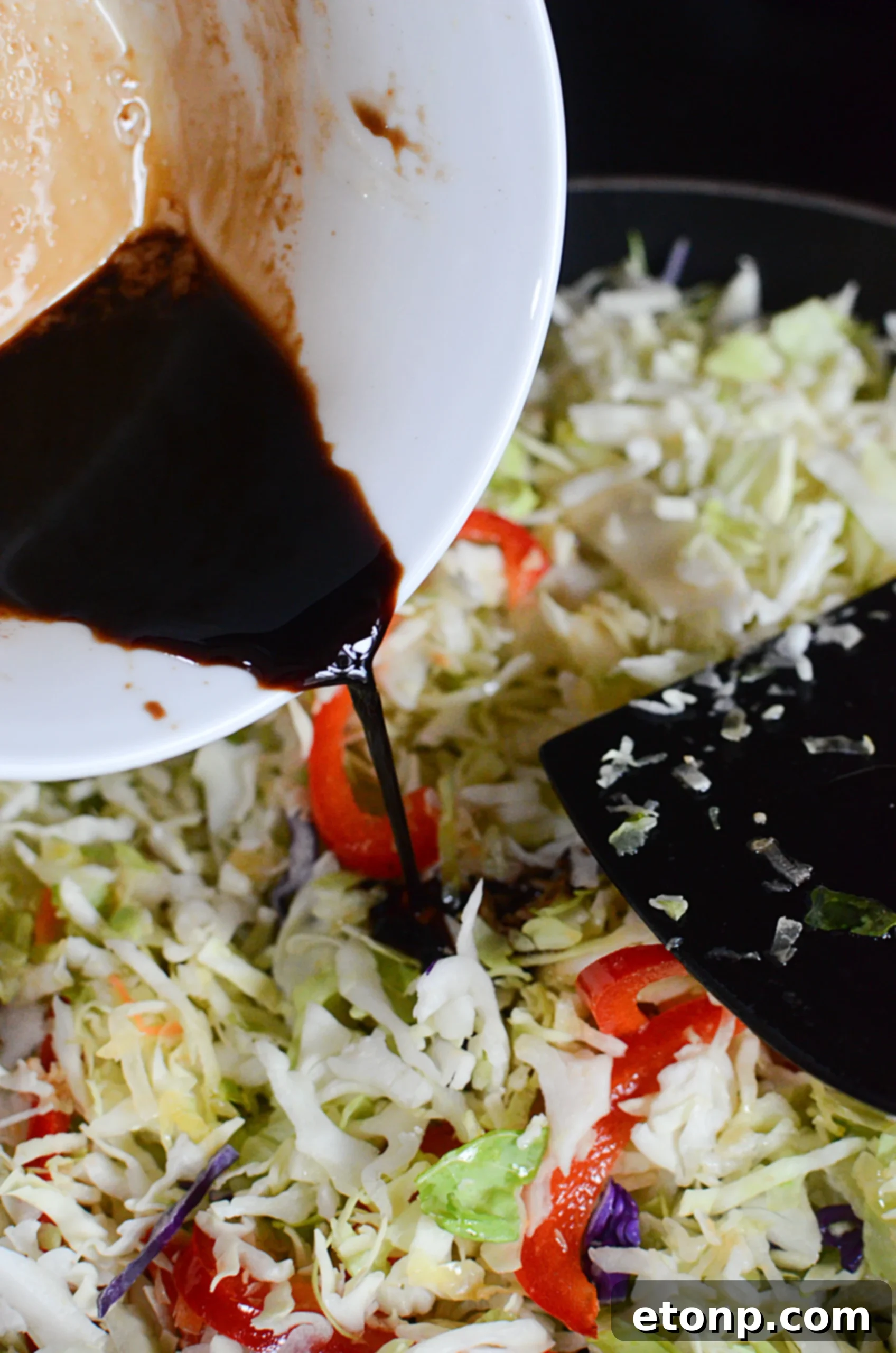 Ground beef browning in a pan with aromatics