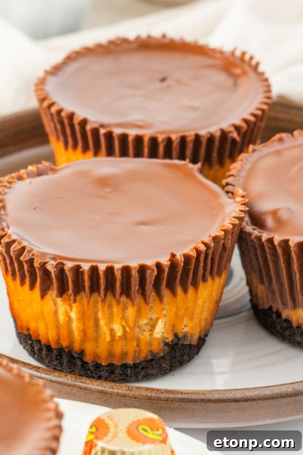 Bite-Sized Peanut Butter Cheesecakes 16 cheesecake cups on plates on table, ready to be served