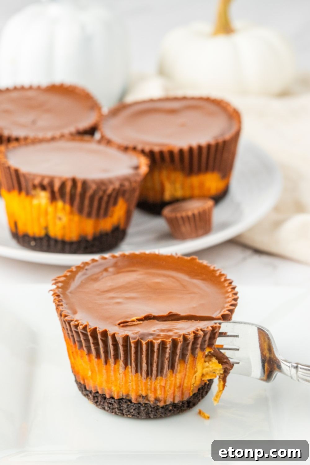 Bite-Sized Peanut Butter Cheesecakes 17 peanut butter cheesecake cupcake with a fork going into the dessert, showing its texture