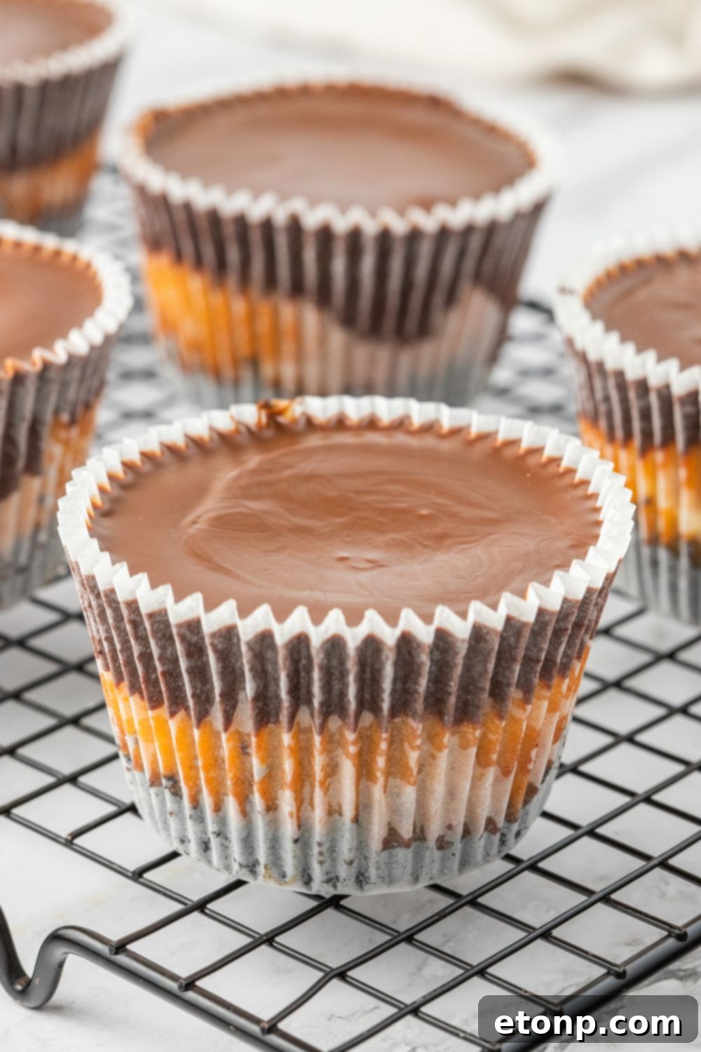 Bite-Sized Peanut Butter Cheesecakes 3 Peanut butter cheesecake cups cooling on a wire rack