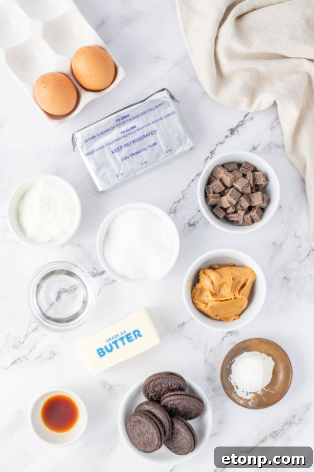 Bite-Sized Peanut Butter Cheesecakes 5 Peanut butter cheesecake ingredients on a marble countertop, ready for baking