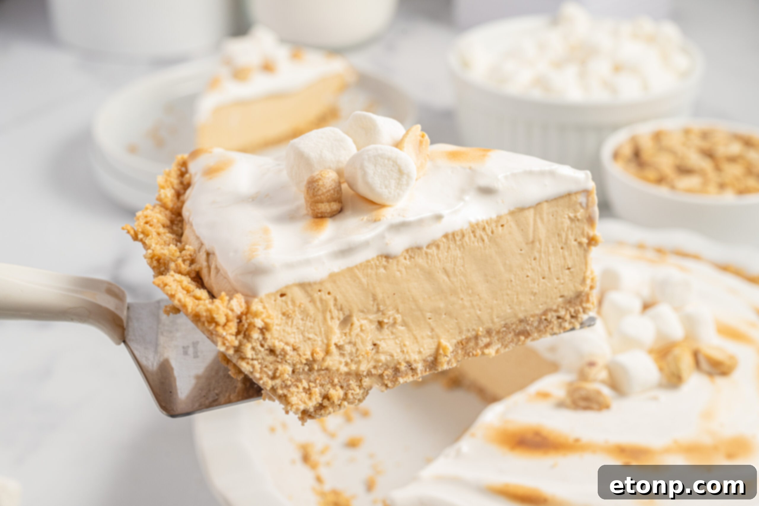 A slice of the Fluffernutter Pie being lifted up out of the pie dish, showing the layers