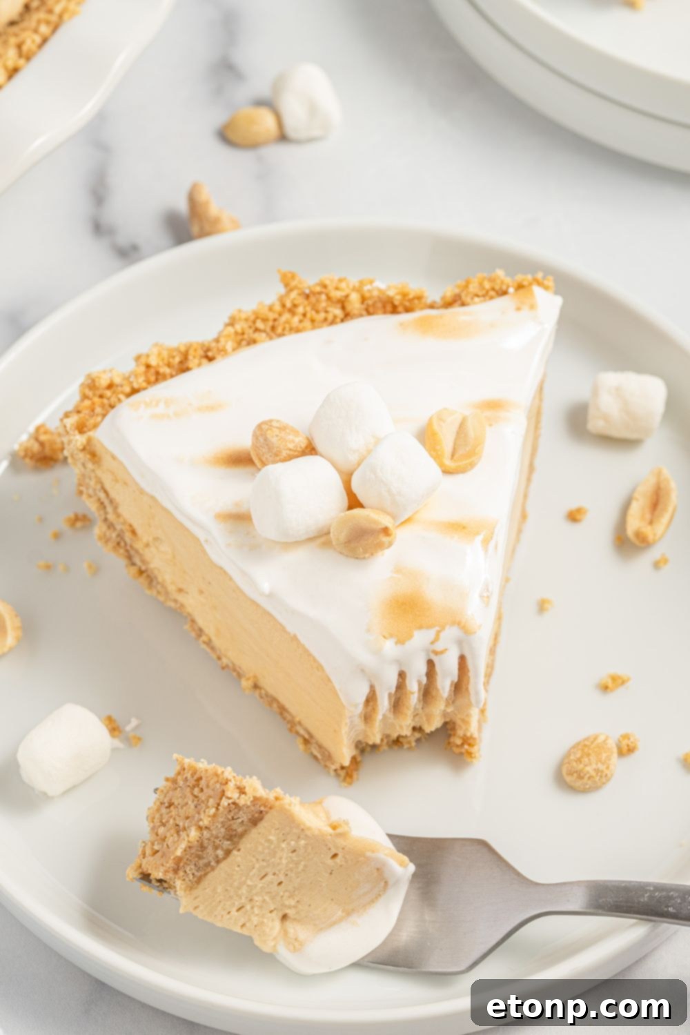 Fluffy Fluffernutter Pie on a plate with a bite taken out, showing its texture