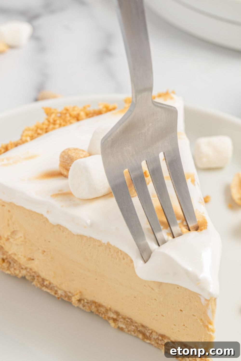 A fork going into a slice of Fluffernutter Pie, showing the creamy texture