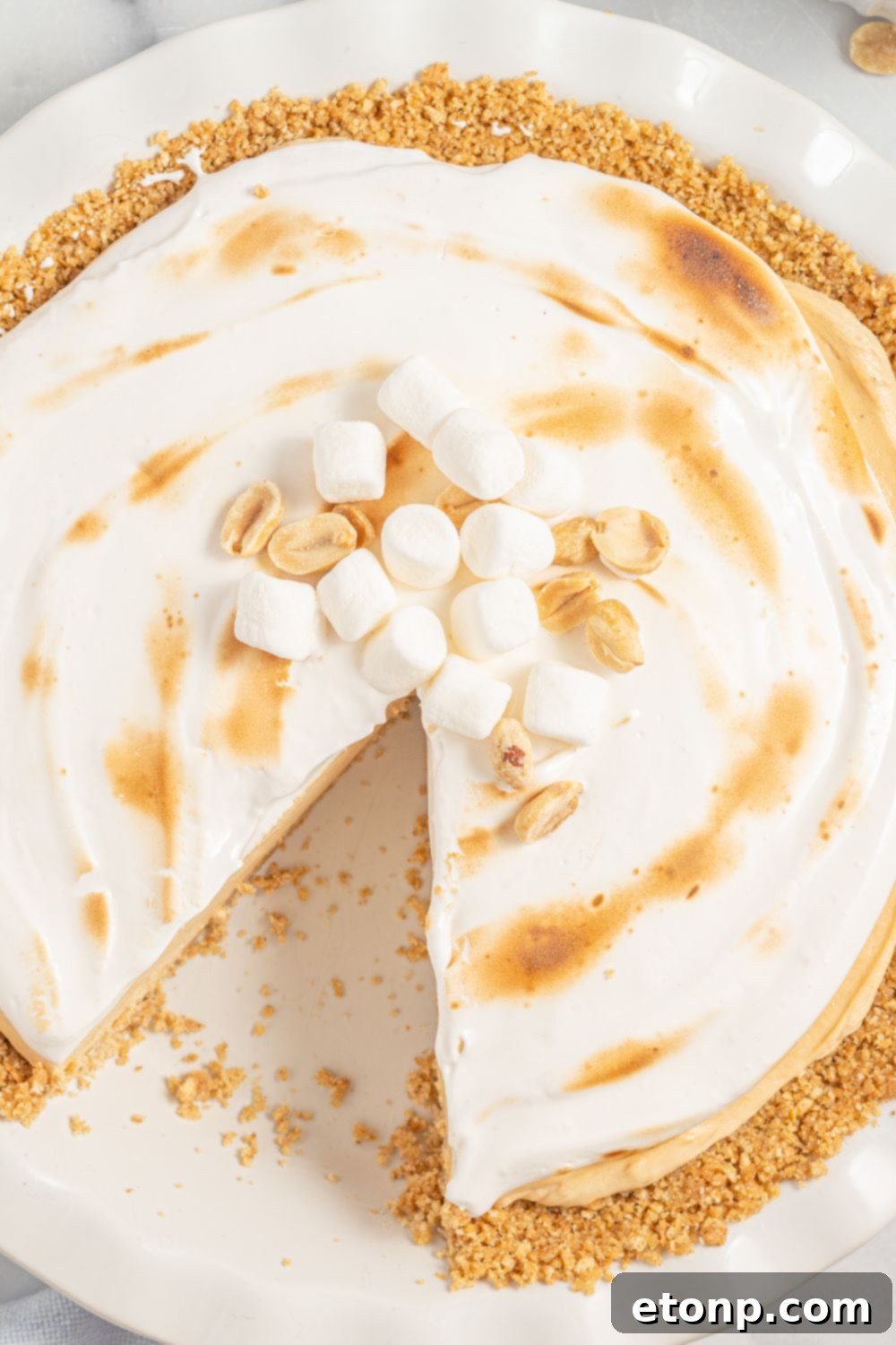 Fluffernutter pie on a platter with a slice taken out, showing off the creamy filling