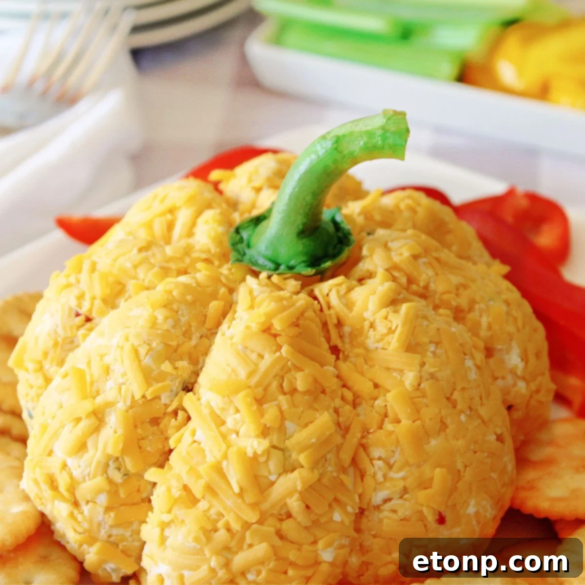Pumpkin Shaped Cheeseball on platter with veggies and crackers around it