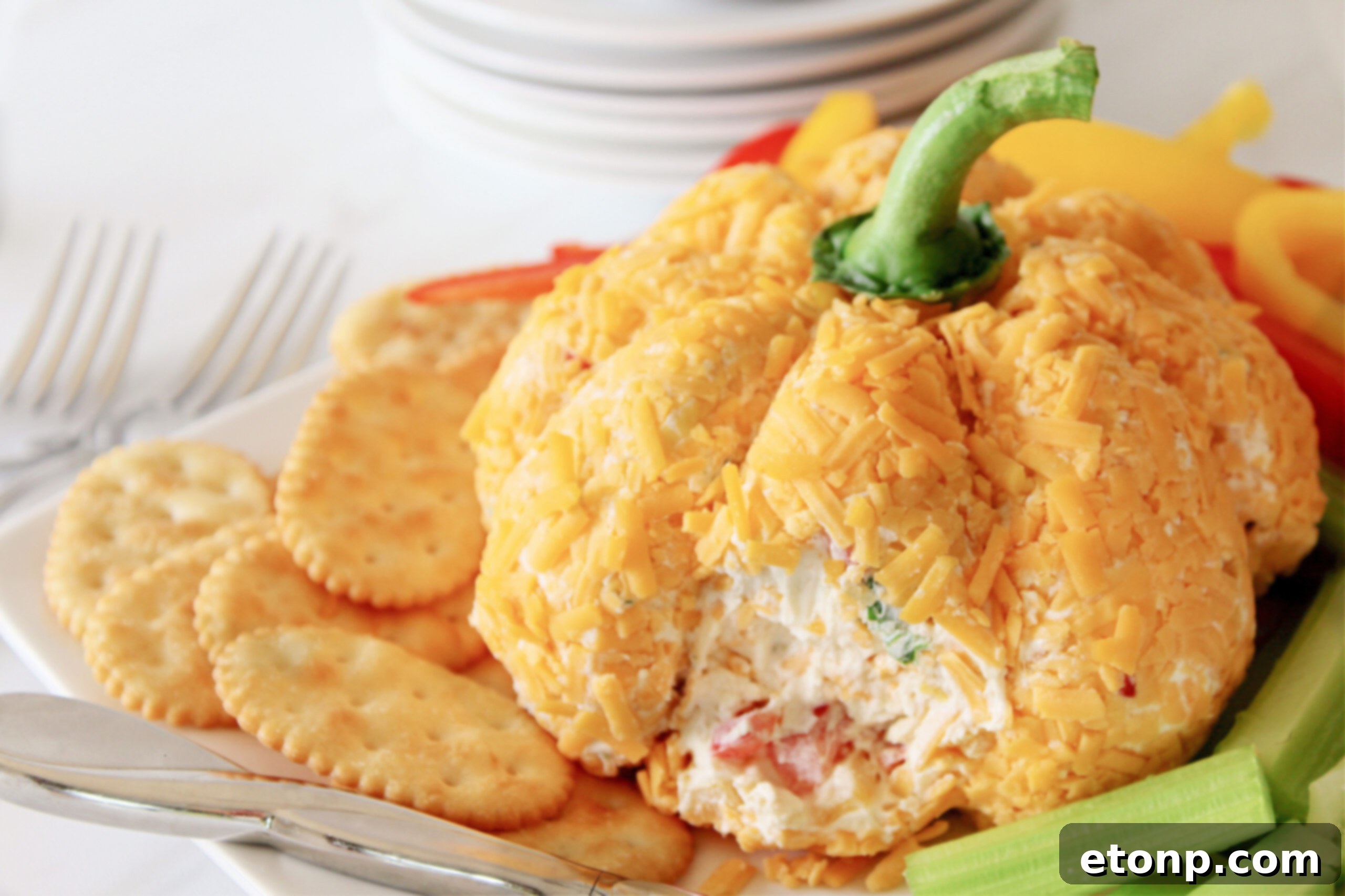 pumpkin cheeseball with part removed from cheeseball to show center