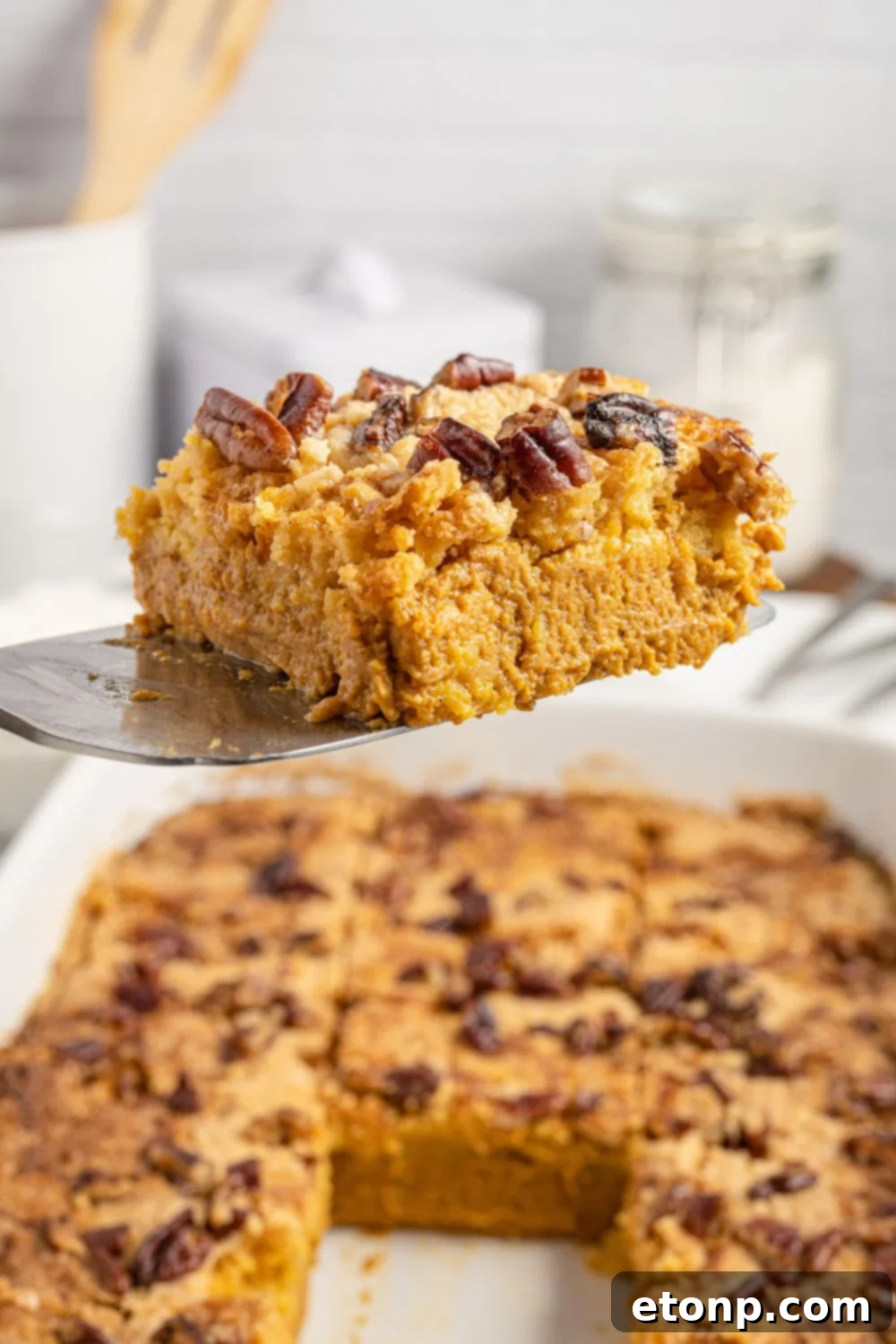 Pumpkin Streusel Cobbler 14 spatula with slice of cake on it above cake pan