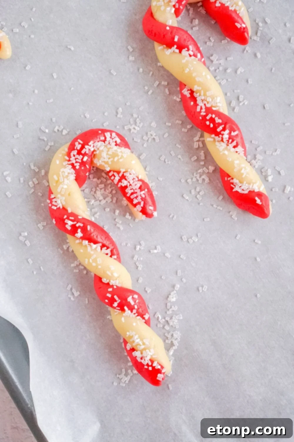 Sweet Peppermint Swirls 12 Shaped sugar cookie candy canes on a baking sheet