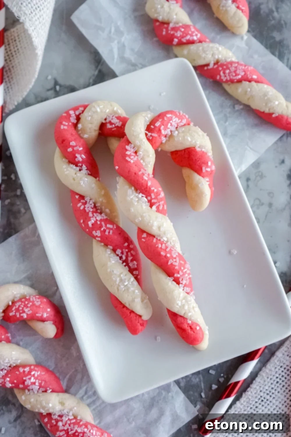 Sweet Peppermint Swirls 19 Christmas cookies on a plate with decorative straw, adding a pop of color