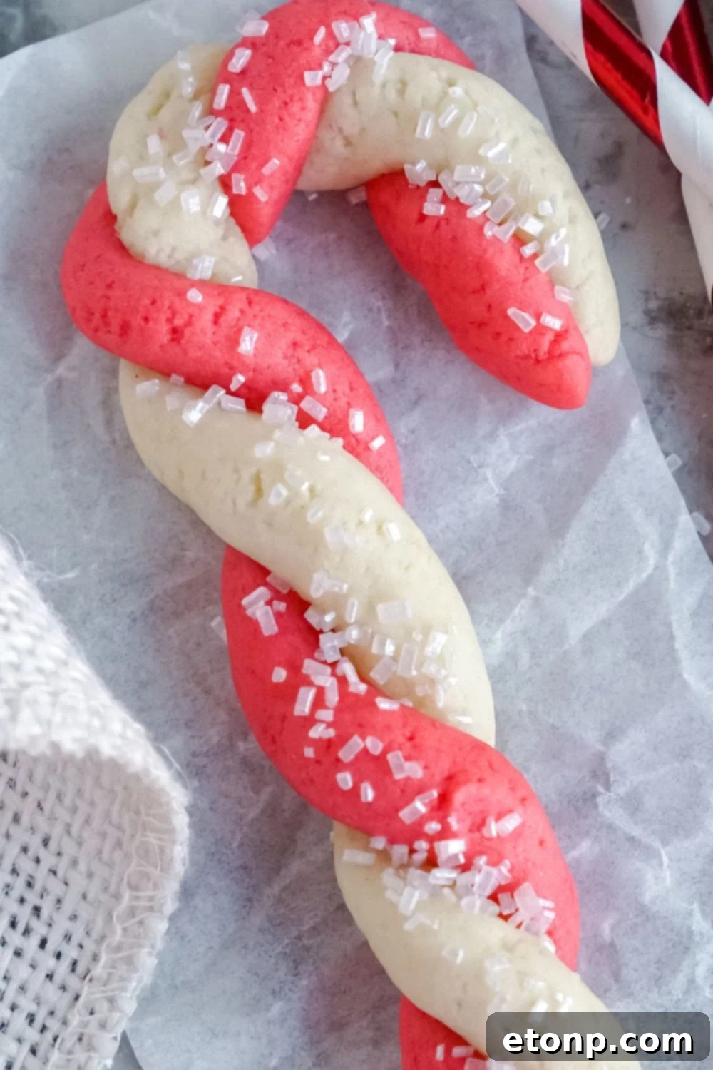 Sweet Peppermint Swirls 22 A sugar cookie candy cane Christmas cookie on parchment paper
