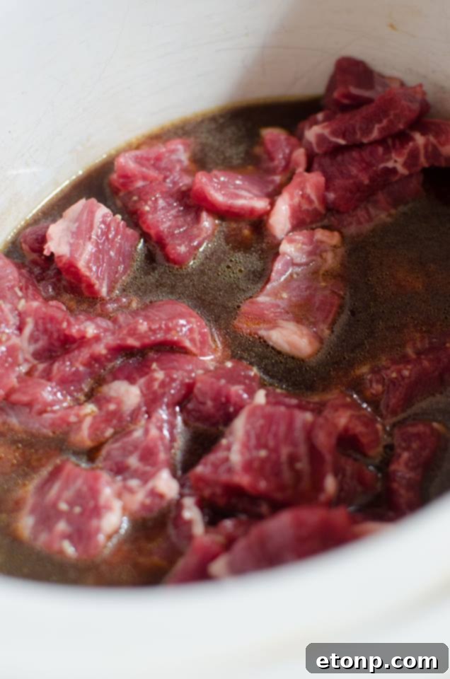 Close-up of tender beef slices in a slow cooker