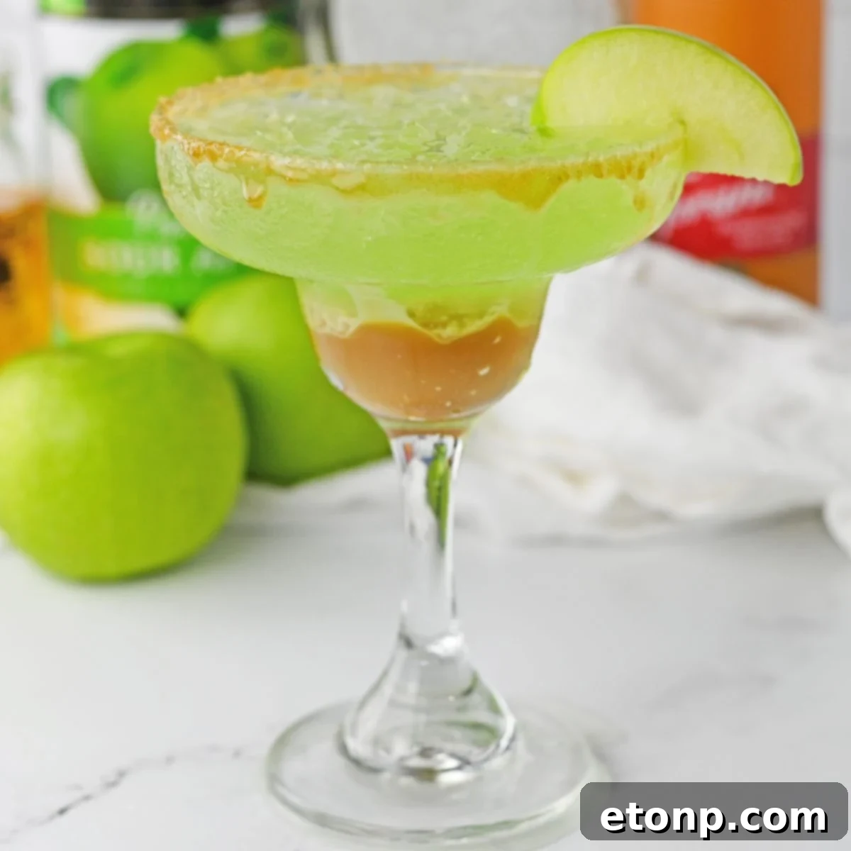 Caramel Apple Margarita on table with apples behind it