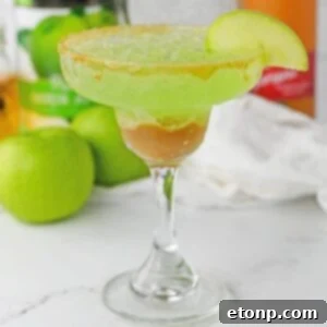 Caramel Apple Margarita on table with apples behind it