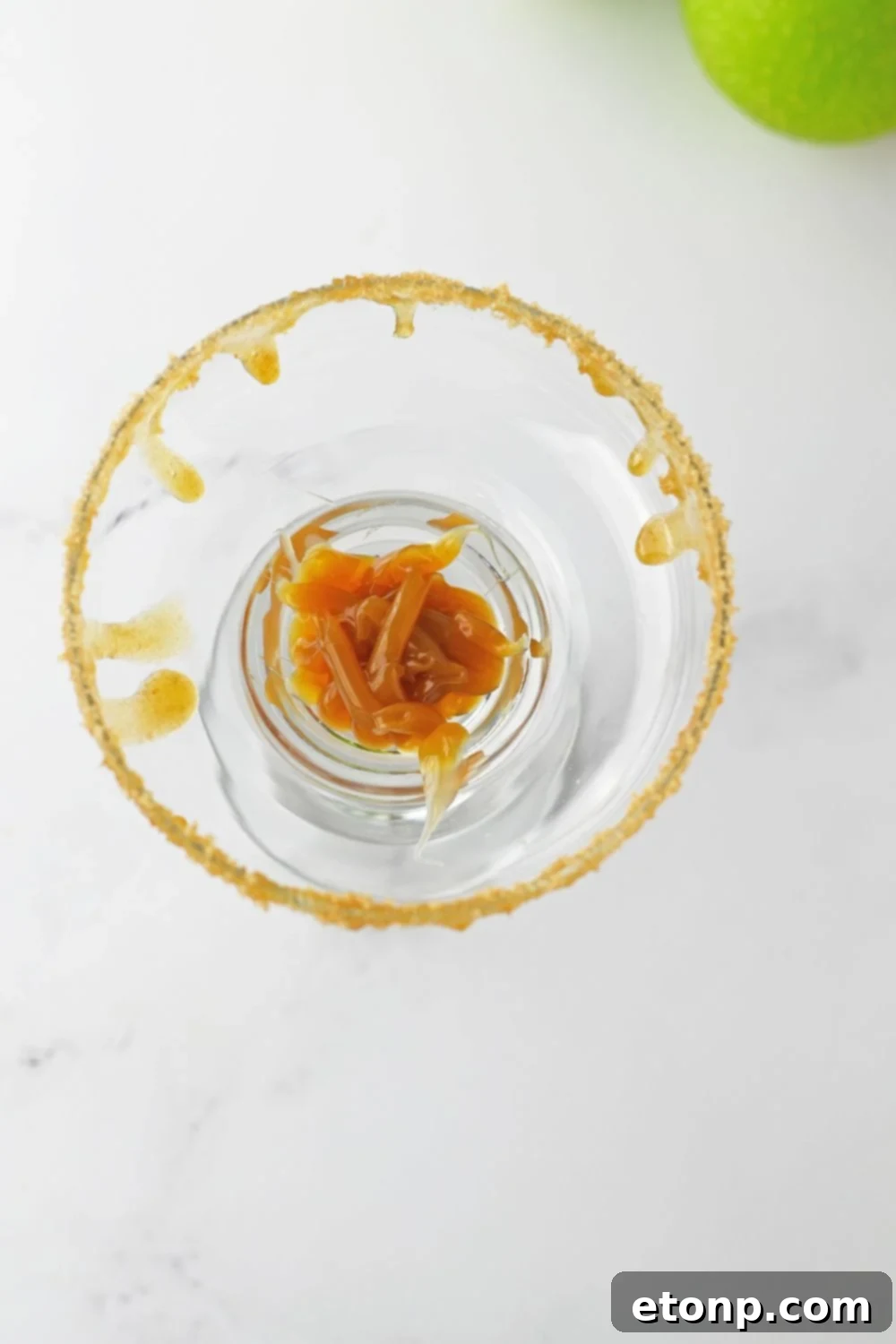 caramel sauce in the bottom of a margarita glass 