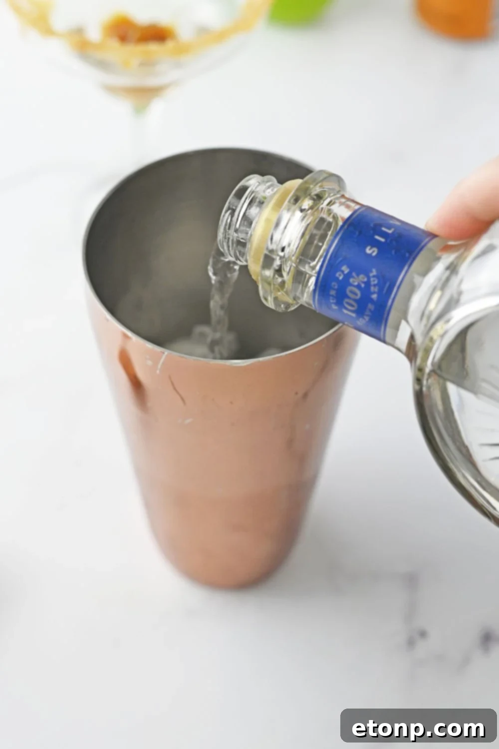 pouring teuila into a shaker