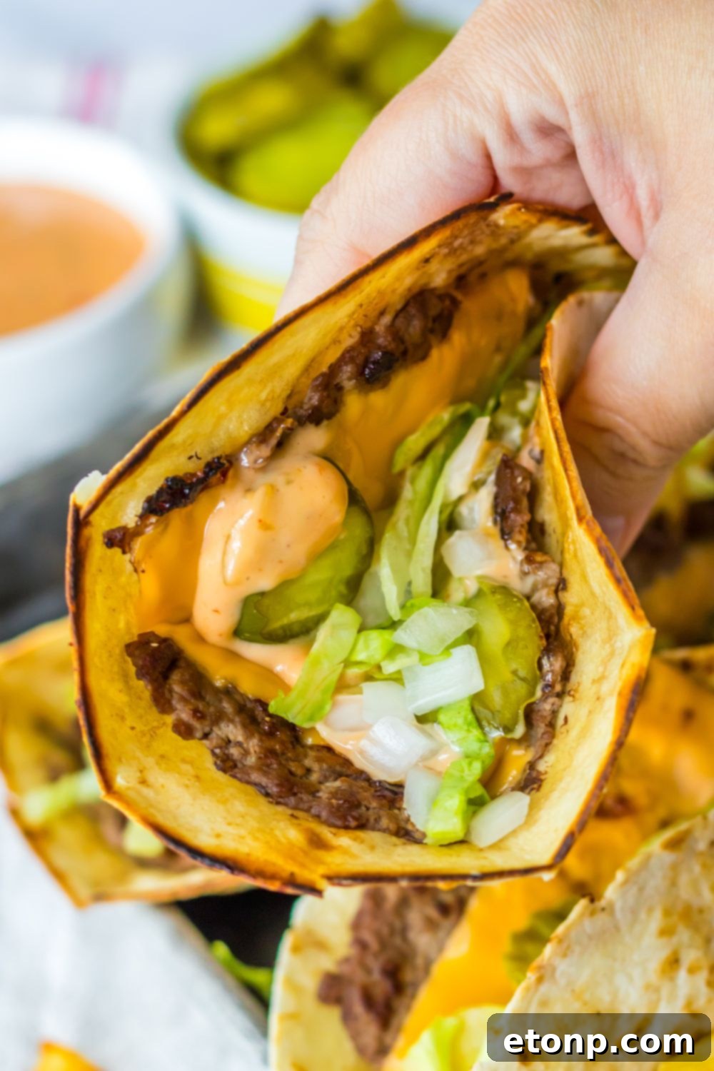 Hand holding a finished Big Mac smash taco