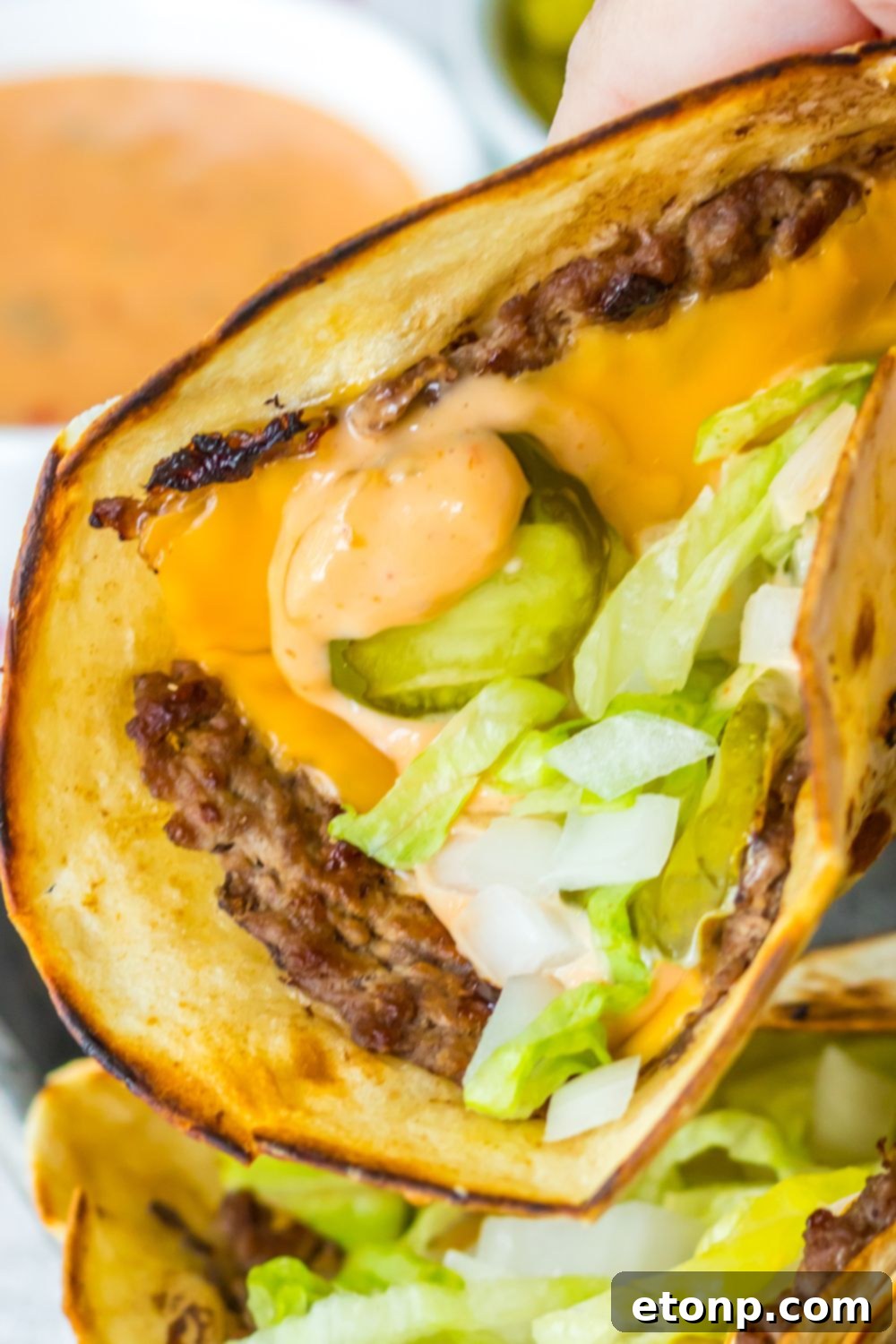 Hand holding a Big Mac smash taco