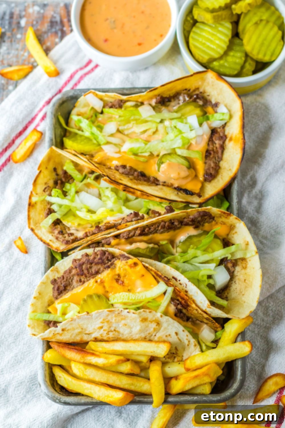 Smash burgers in taco form, garnished with fresh toppings