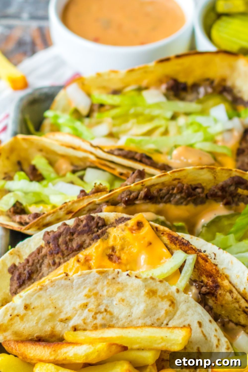 Easy Big Mac smash tacos on a plate with sauce behind it in a container