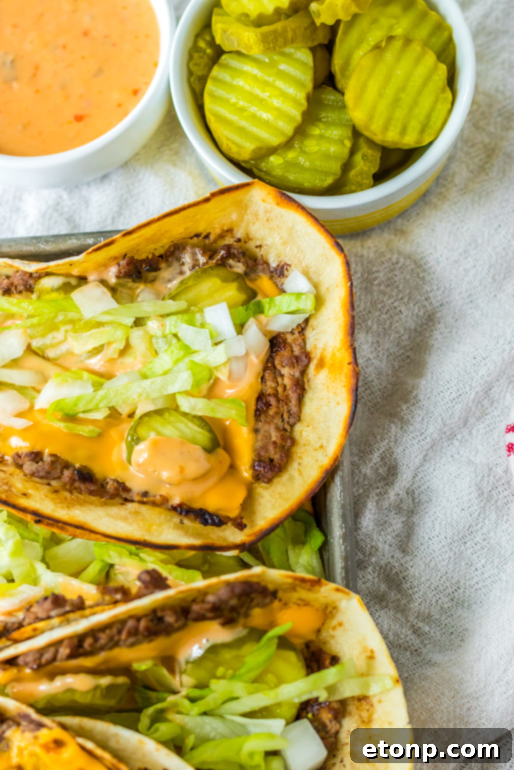 Close-up of Big Mac smash tacos, highlighting the texture and fresh toppings