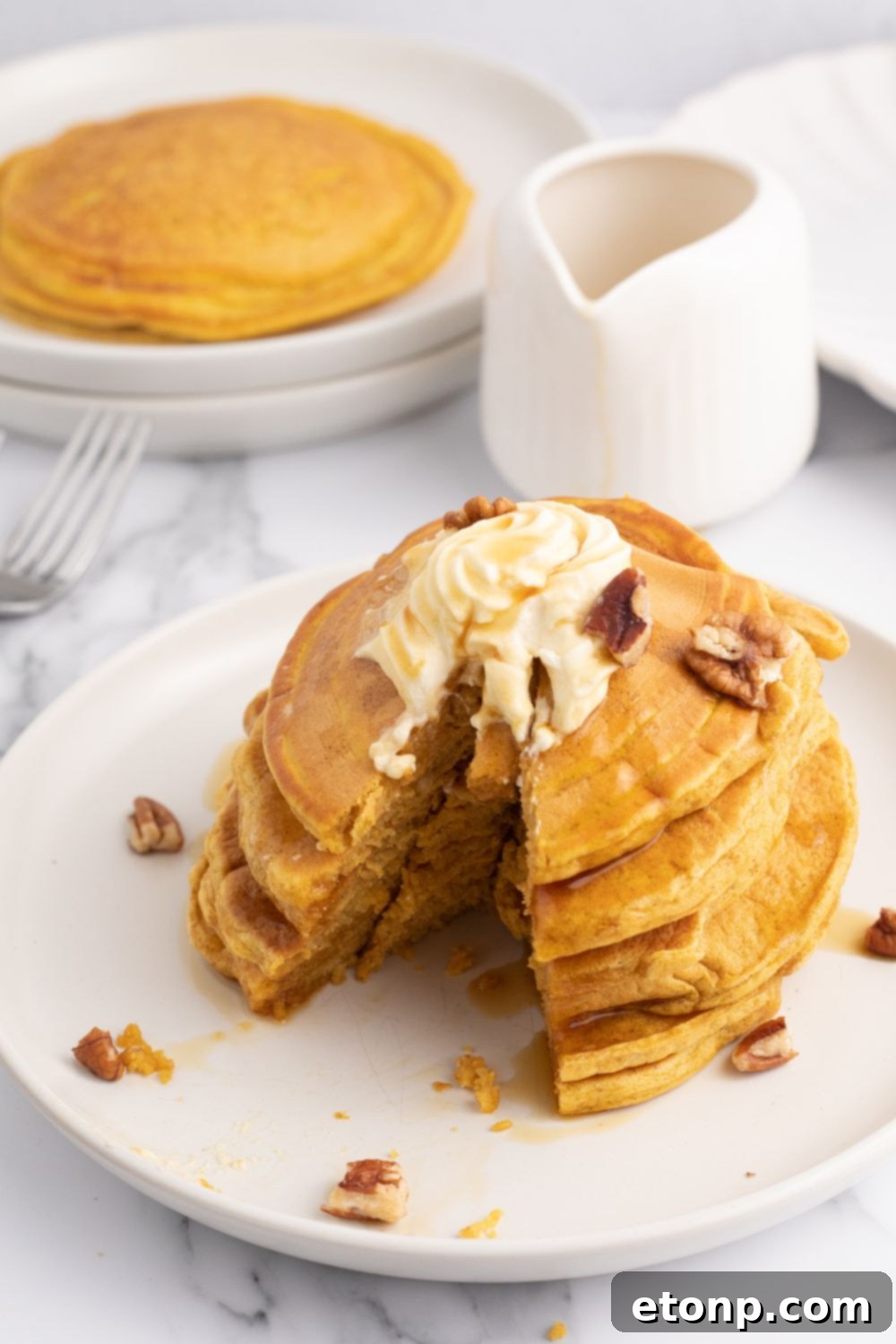 A slice of pumpkin pancake with a bite taken out, showing the fluffy inside