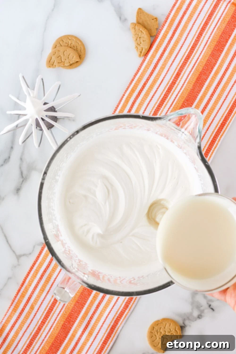 A decadent mixture of whipped cream and sweetened condensed milk in a mixing bowl, forming the luxurious no-churn ice cream base.