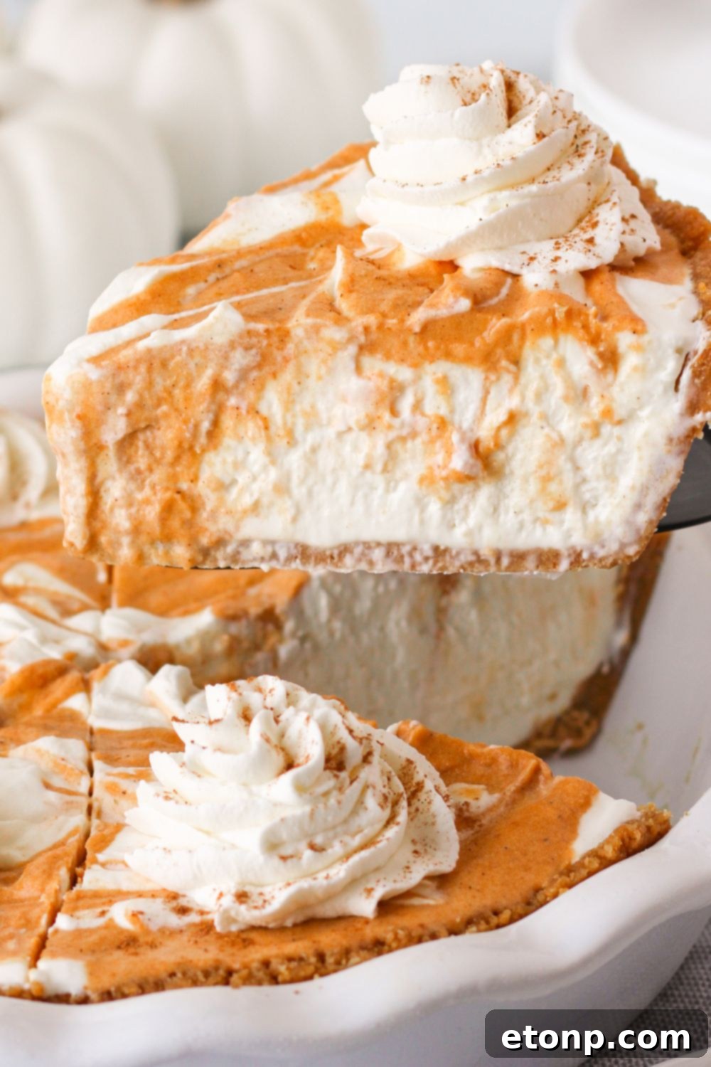 A tantalizing pumpkin cream cheese pie with a slice elegantly lifting out, showcasing its rich layers and creamy filling.