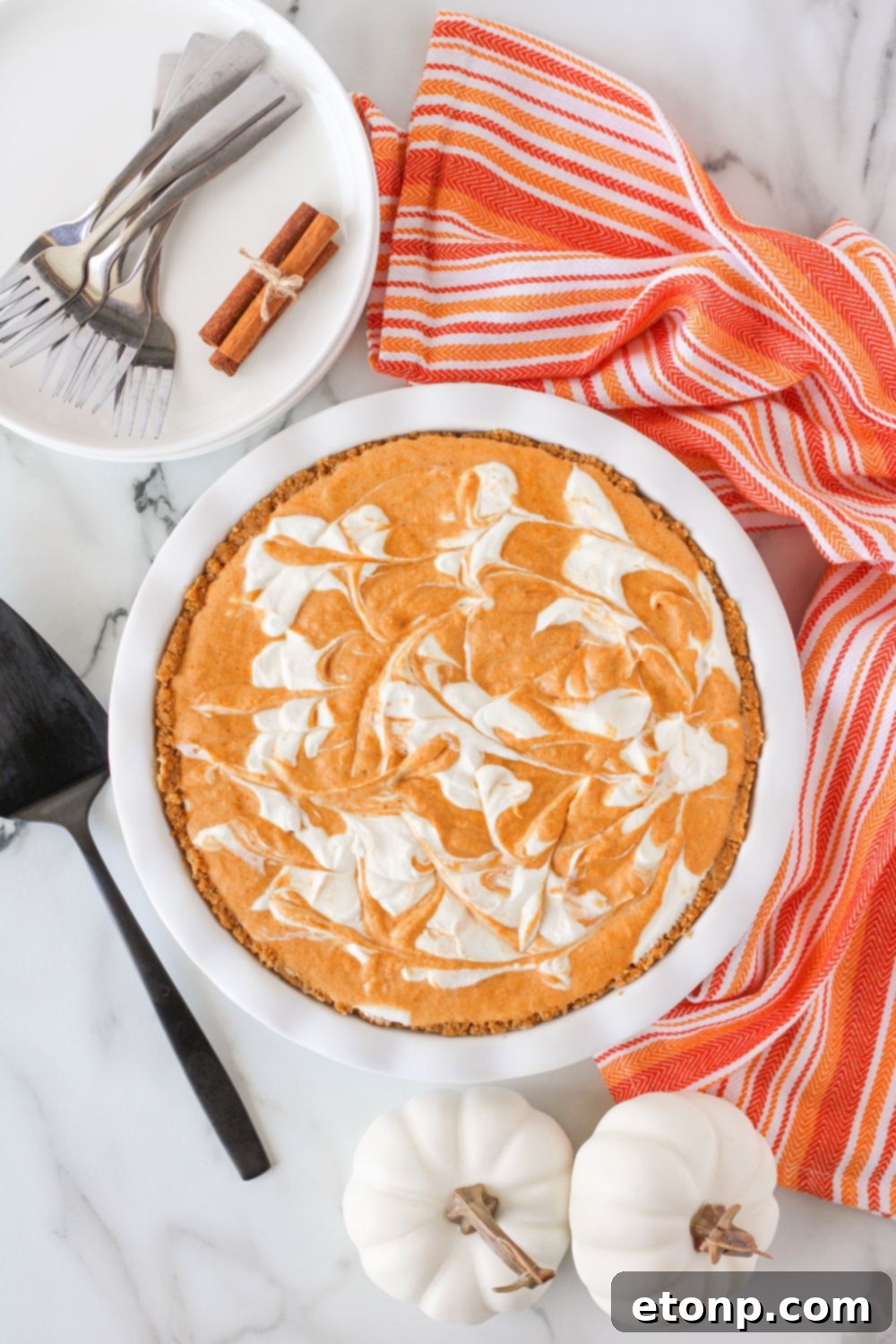 An inviting overhead shot of the Pumpkin Ice Cream Pie resting on a chic marble countertop, accentuating its visual appeal and autumnal vibe.