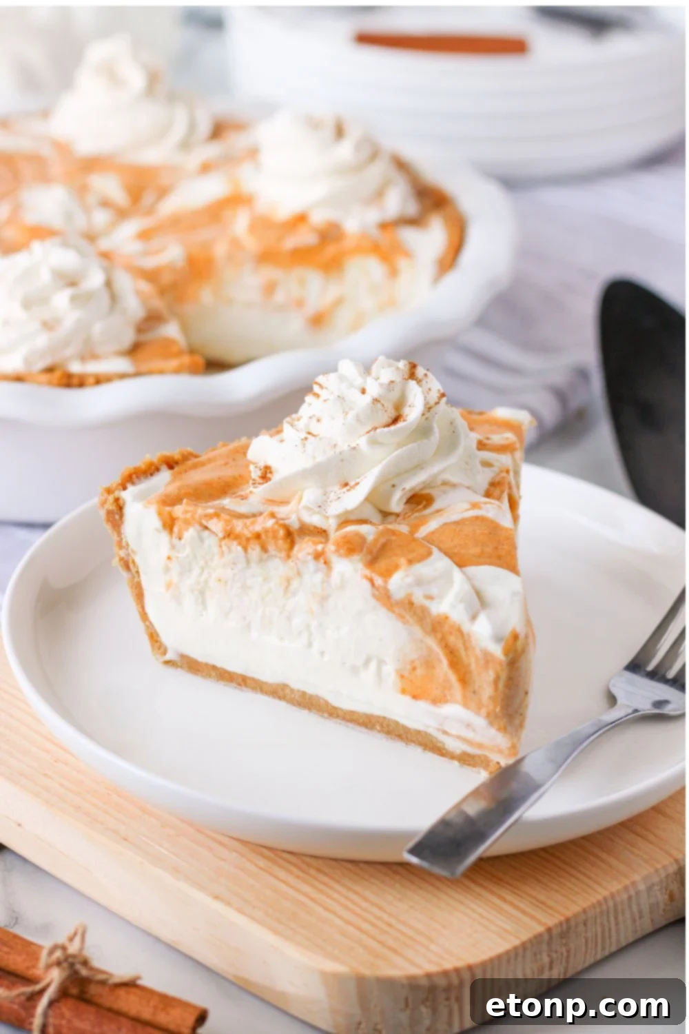 A tempting slice of pumpkin pie ice cream on a plate, with a fork resting beside it, ready for a delightful indulgence.