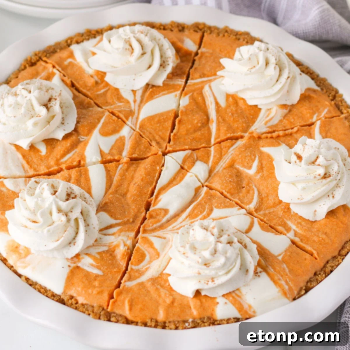 A whole Pumpkin Ice Cream Pie elegantly displayed in its pan on a rustic wooden table, inviting guests to indulge in its autumnal charm.