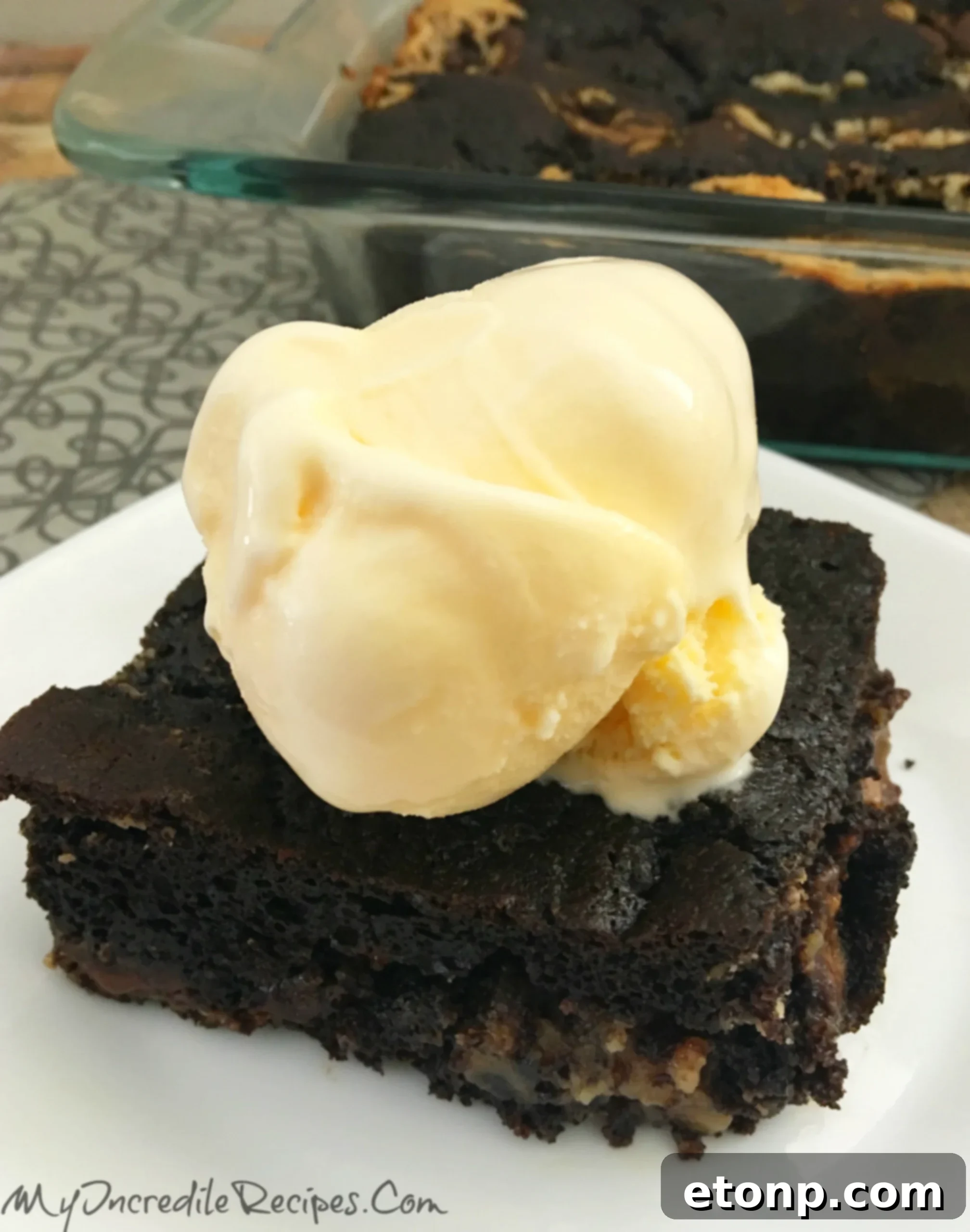 A close-up of a fork taking a bite of Peanut Butter Earthquake Cake with melted ice cream