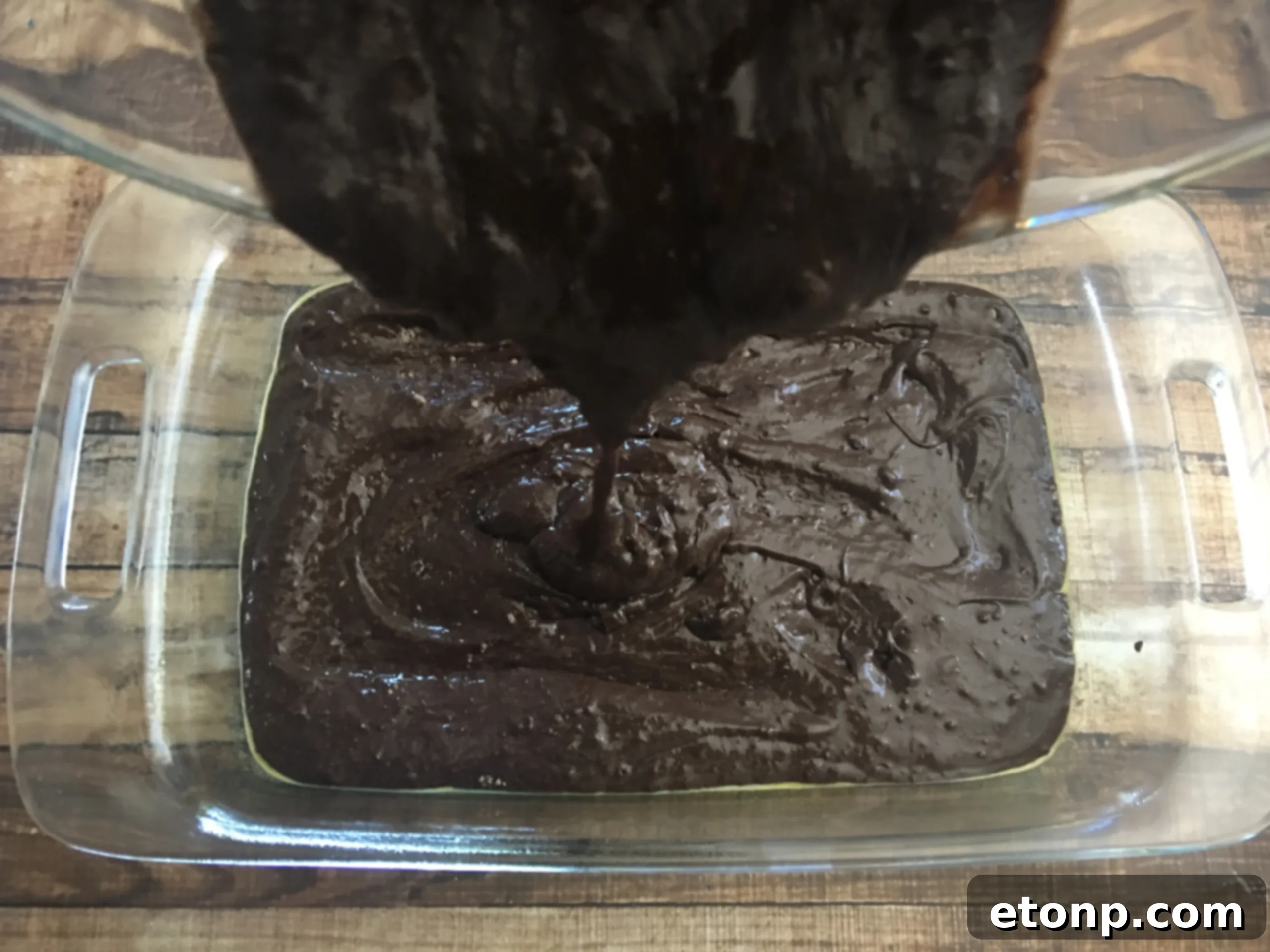 Adding powdered sugar to the peanut butter cream cheese mixture, creating a rich, thick topping