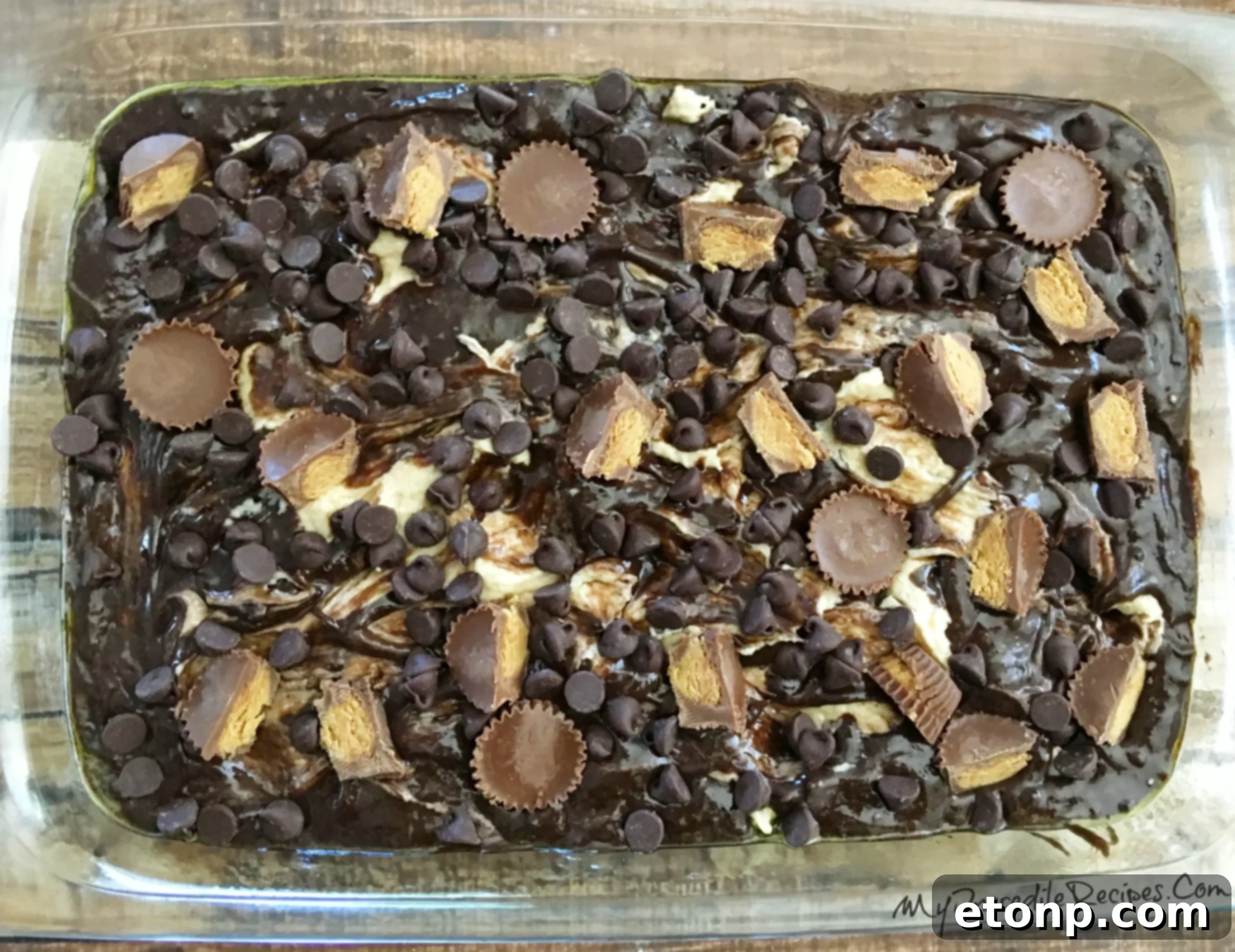 The peanut butter cream cheese mixture being dolloped onto the chocolate cake batter, ready for swirling