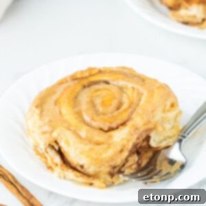 Pumpkin Cinnamon Roll on plate with a fork on the side
