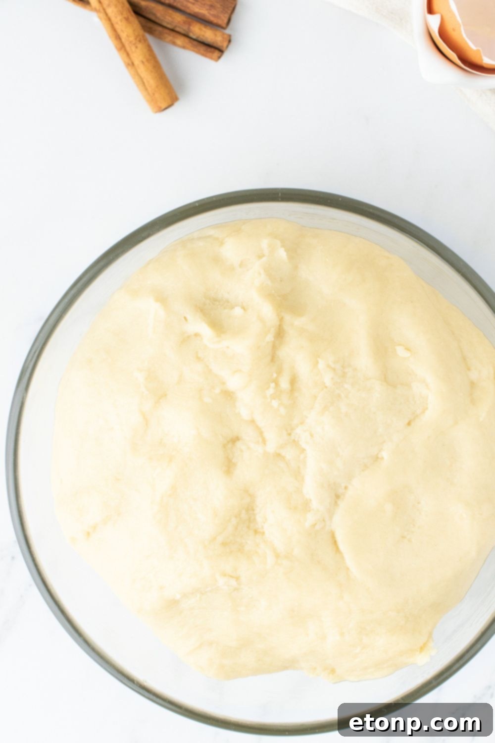 Dough in a glass bowl, visibly risen and ready for shaping