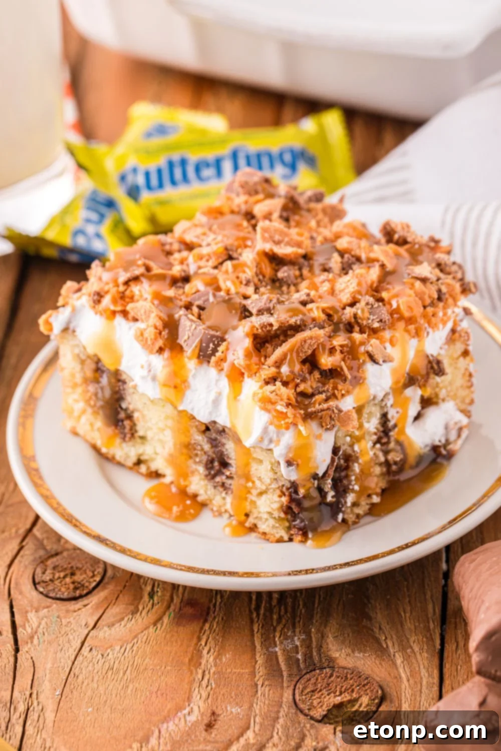 slice of cake on plate with butterfinger candy bars in the back