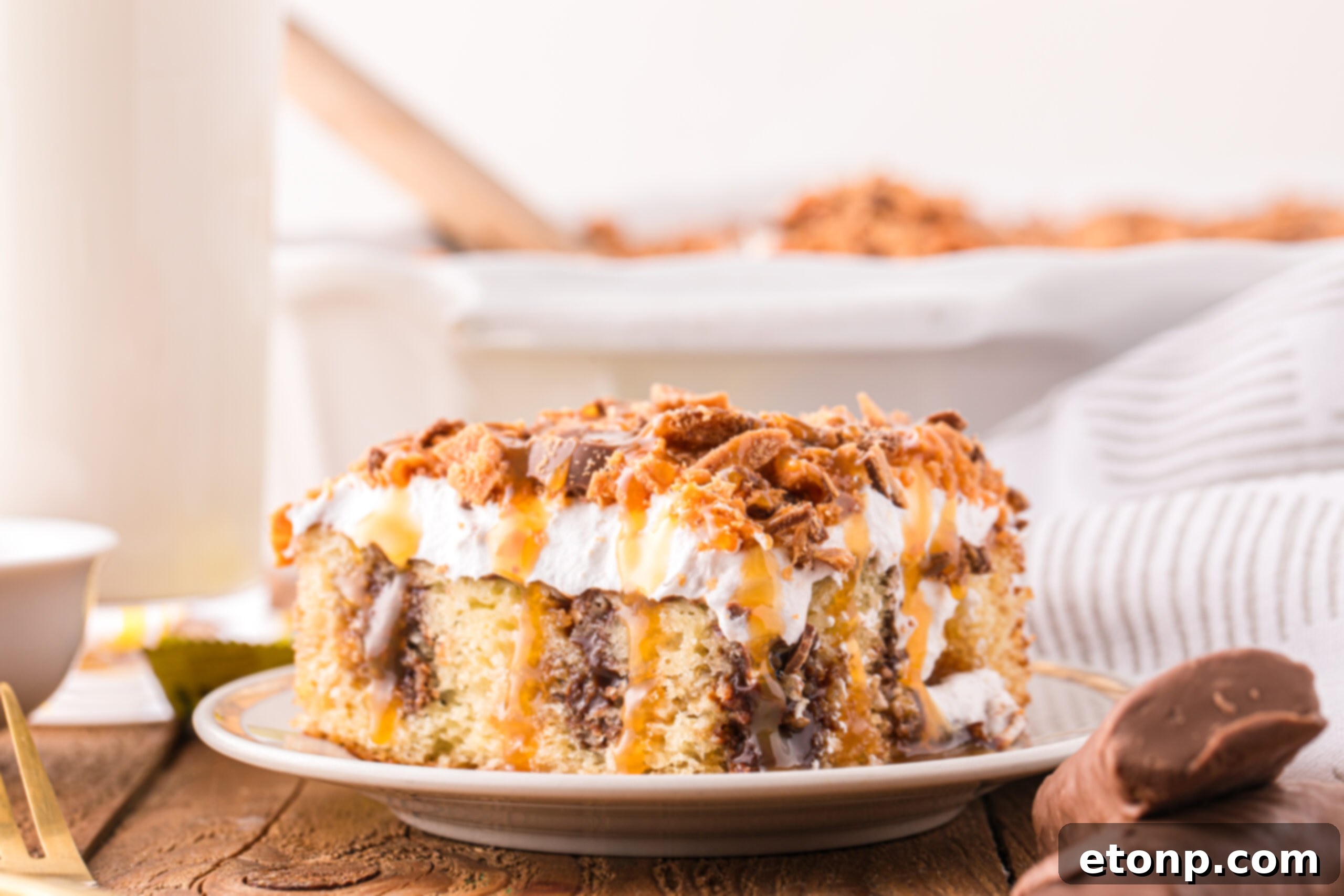 Butterfinger Poke Cake on a white plate 