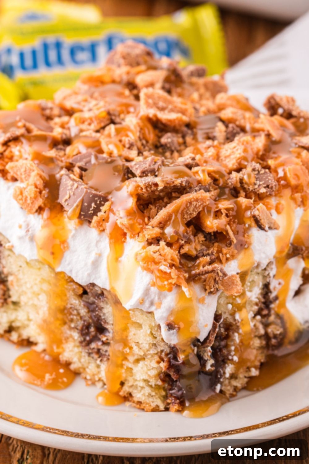 slice of cake on a plate with butterfinger candies in the background