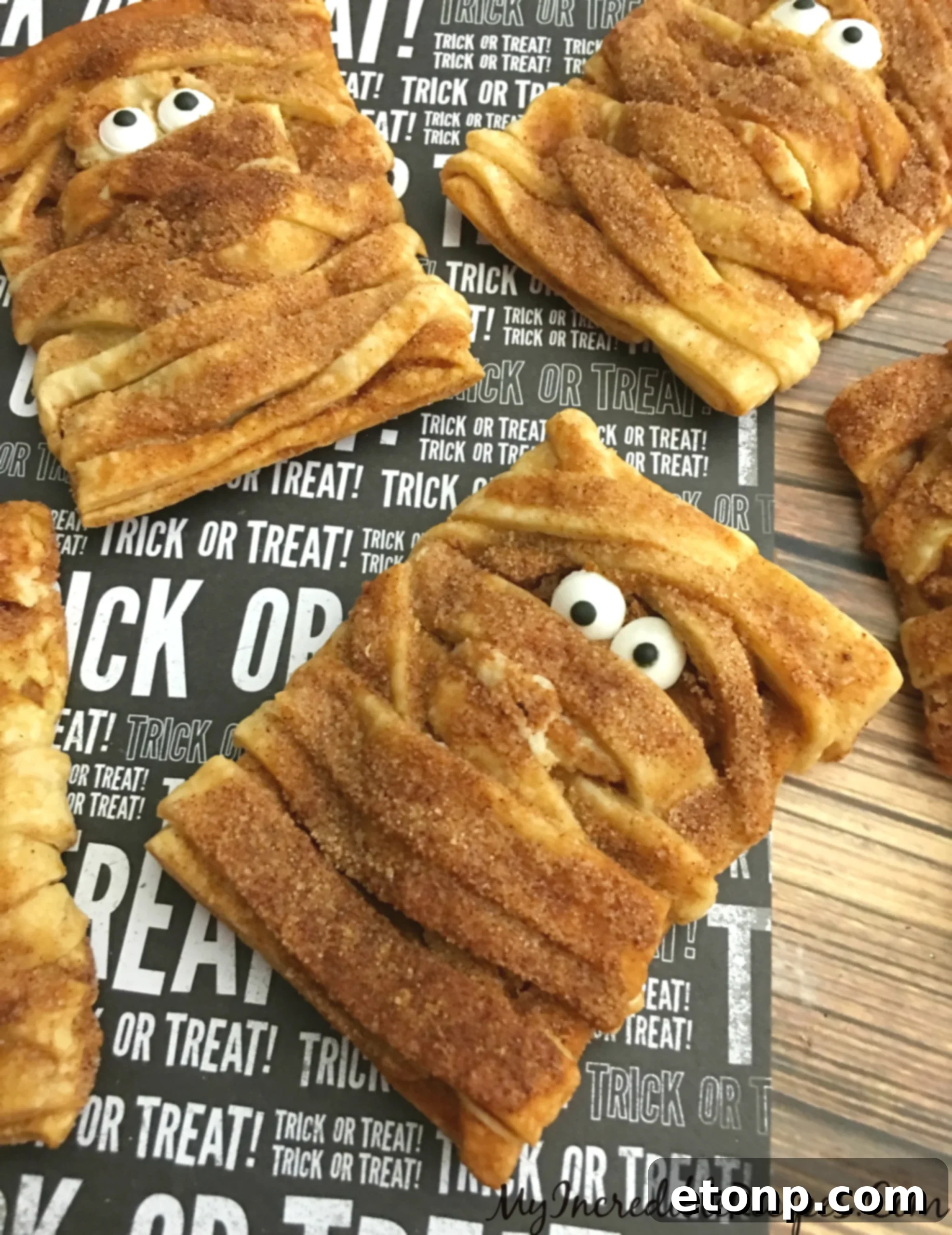 Adorable pumpkin cheesecake mummy hand pies, perfect for Halloween parties and kid-friendly treats.