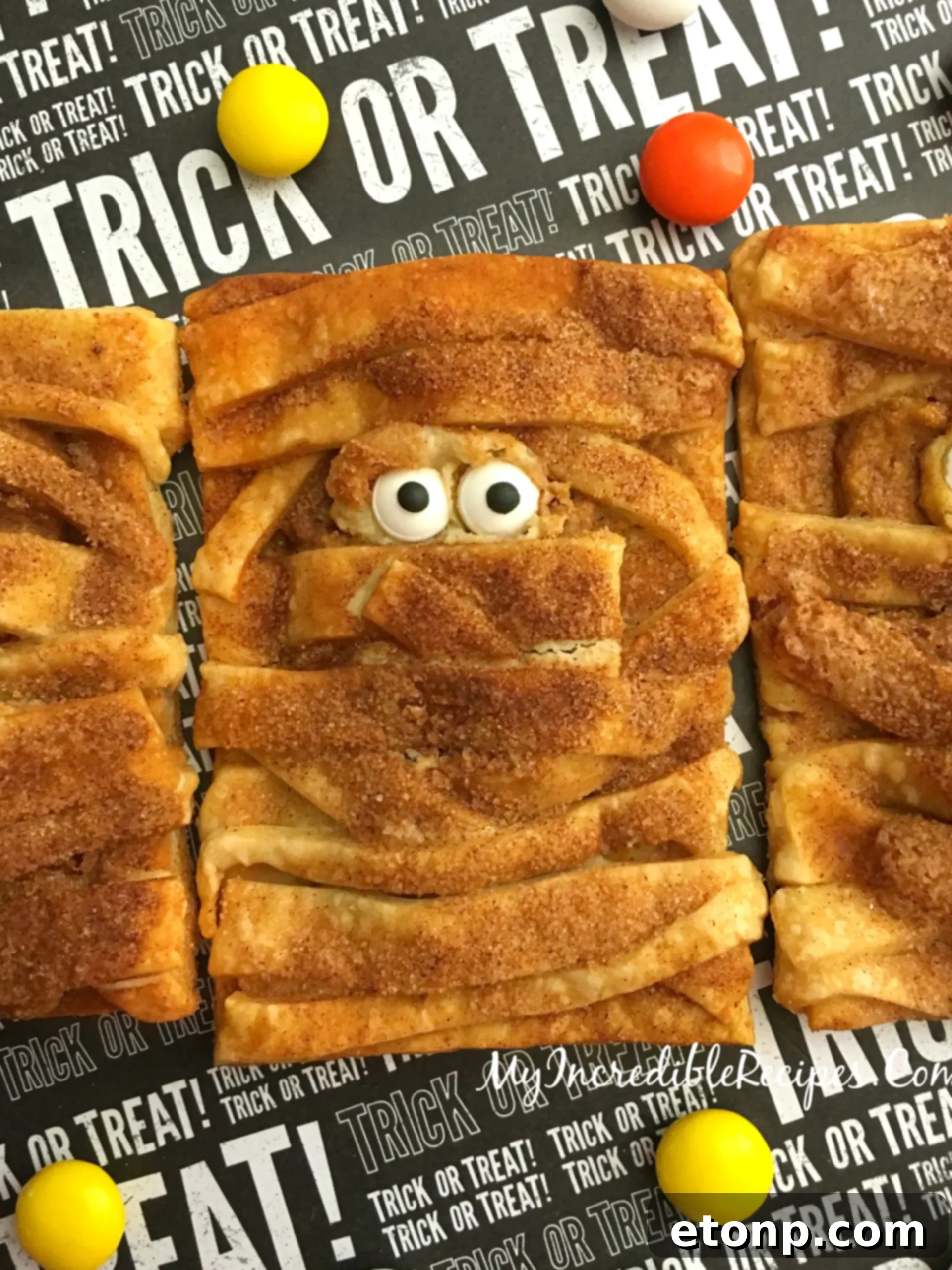 A close-up view of the adorable pumpkin cheesecake mummy hand pies, showcasing their inviting texture.