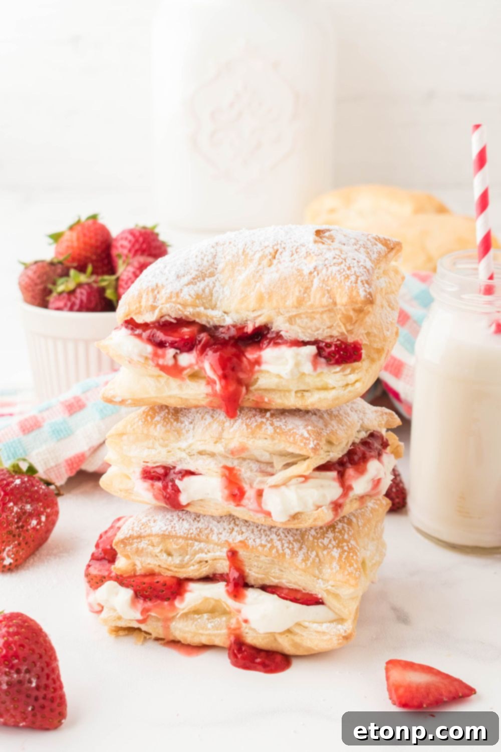 A beautiful stack of puff pastry desserts, artfully arranged on a table, highlighting their golden-brown color and inviting texture.