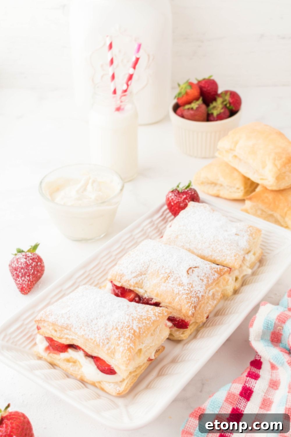 A long tray filled with multiple Drake's-style strawberry desserts, perfectly lined up and ready for serving.