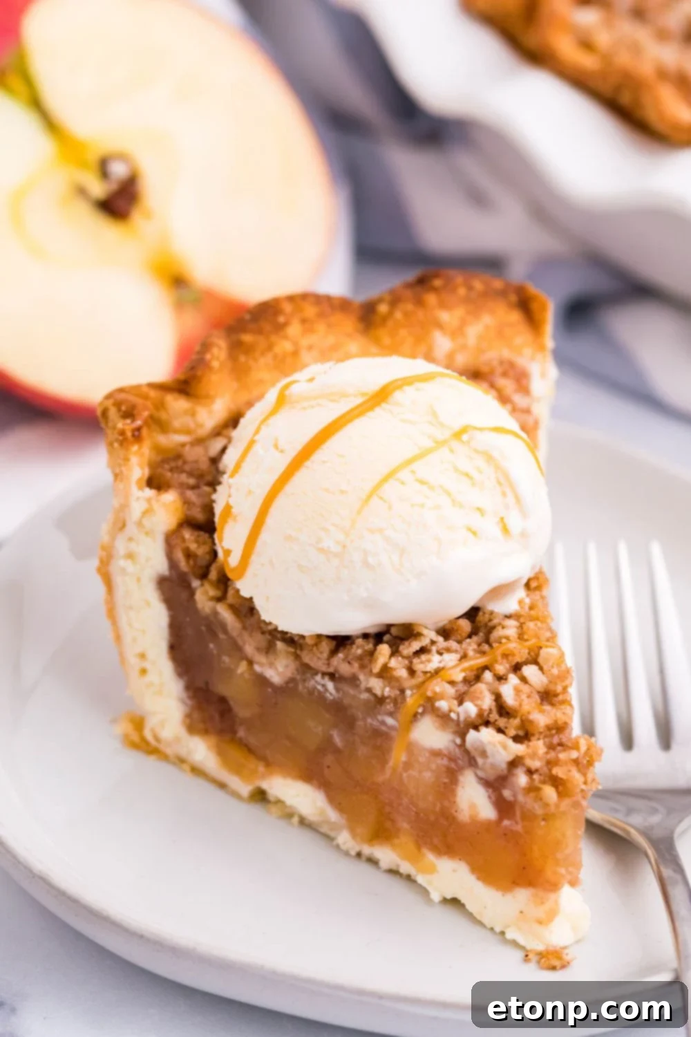 apple crisp cheesecake with ice cream with a drizzle of caramel sauce